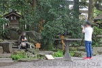 川越氷川神社 戌岩で記念撮影している女性の様子