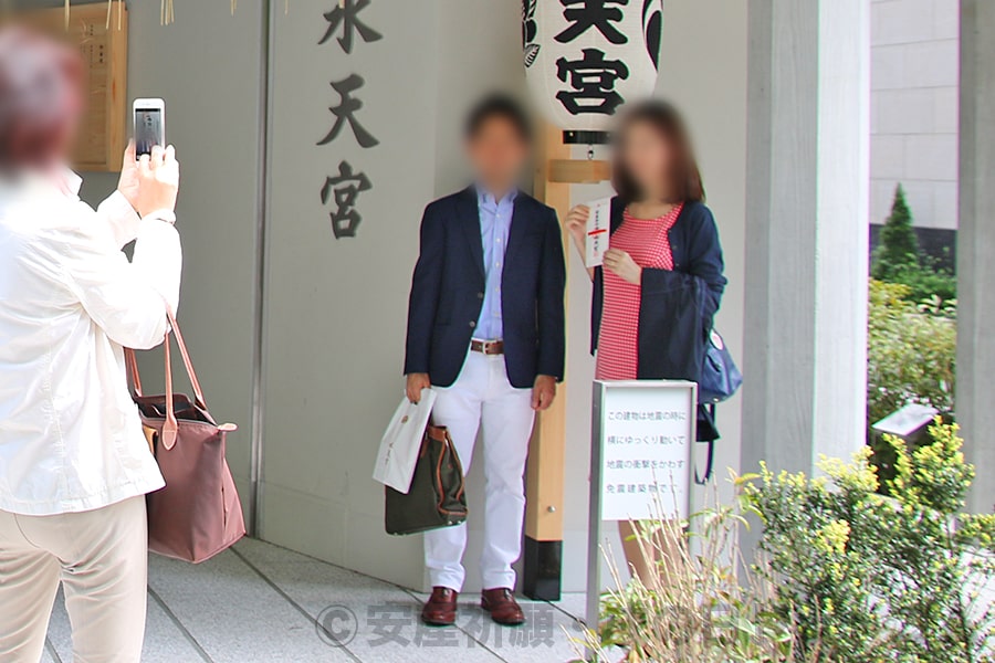 同じく春の時期の戌の日に水天宮境内入口で記念撮影する妊婦ママさんたち服装の様子