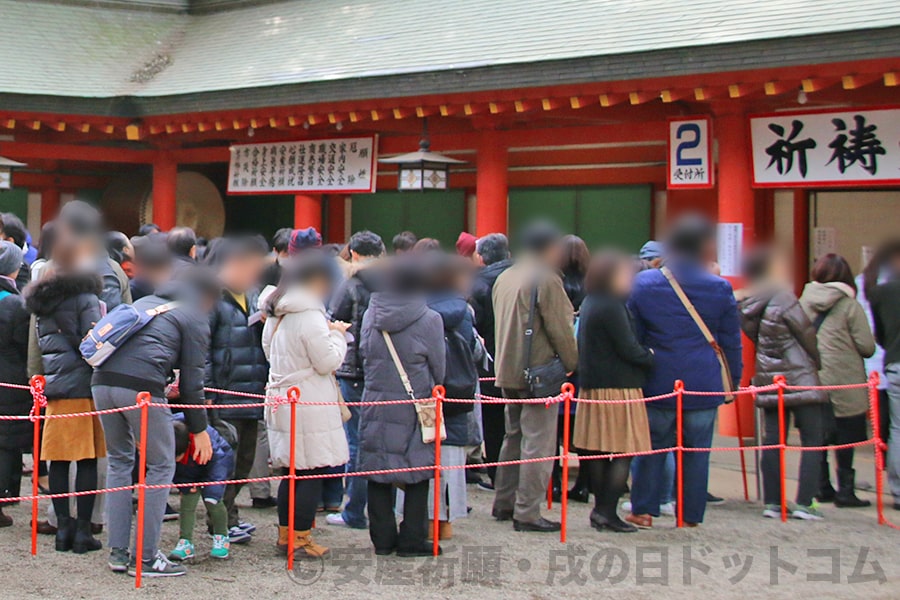 寒い冬の戌の日に御祈祷申し込みの行列と並んでいる妊婦ママさんがみんなしっかり着込んで防寒に備えている様子（大宮氷川神社）